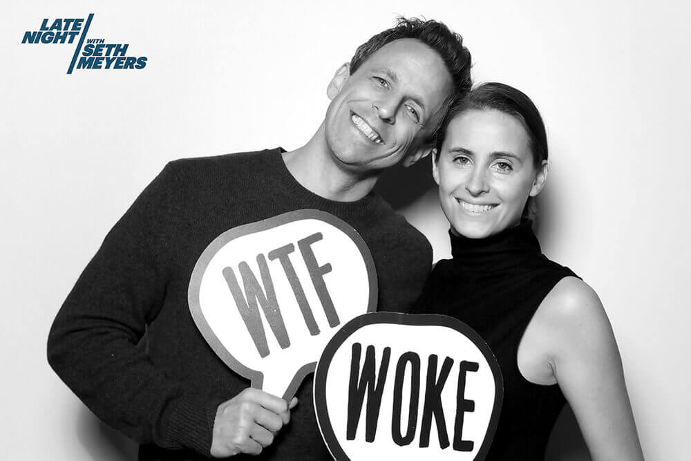Photo Booth at the Late Night with Seth Meyers Show Seth Meyers and wife Alexa Ashe pose in a black and white image with a photo booths sign prop that reads "WTF" and "Woke"